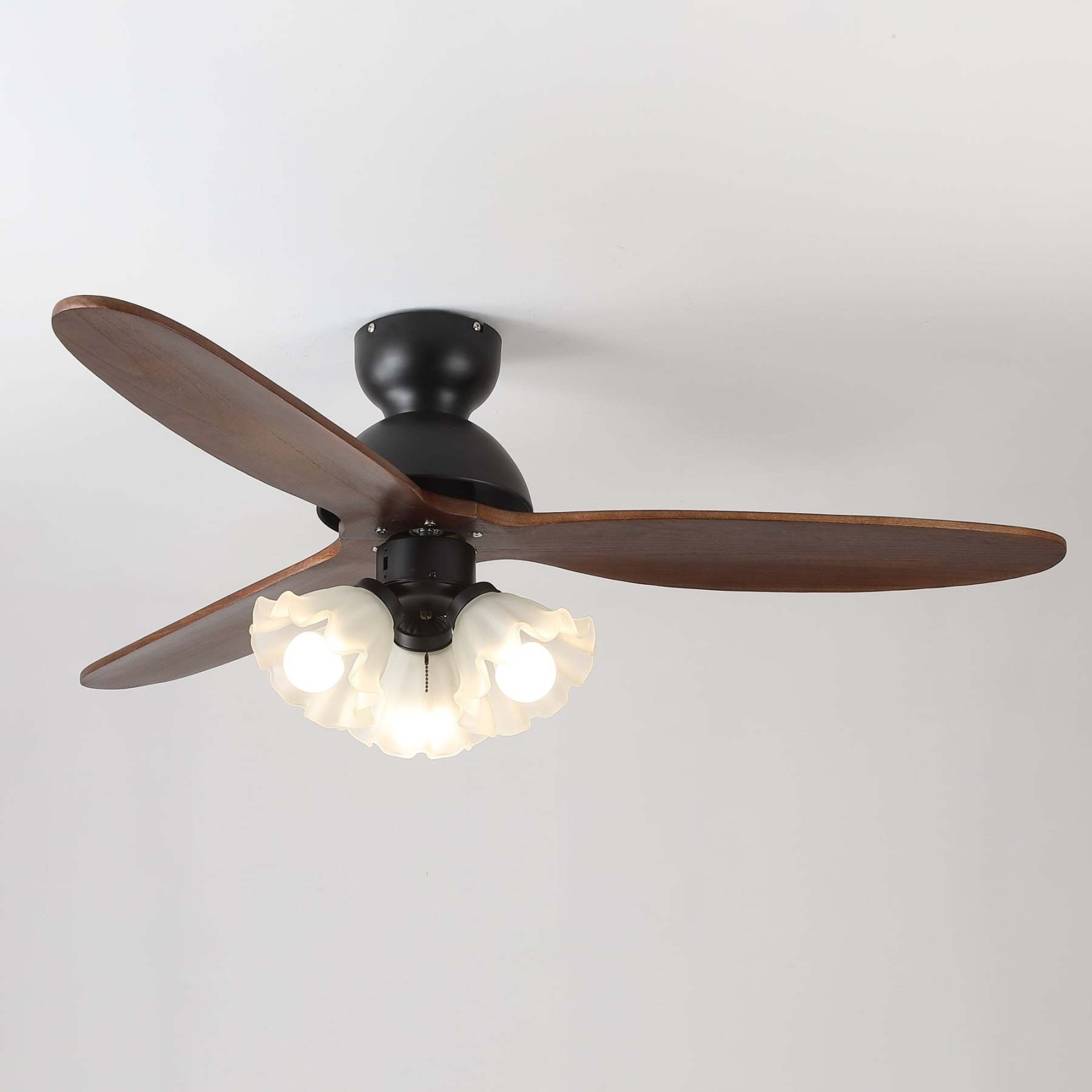 Ventilador de techo con luz mostrando detalles de su estructura metálica y pantalla de cristal.
