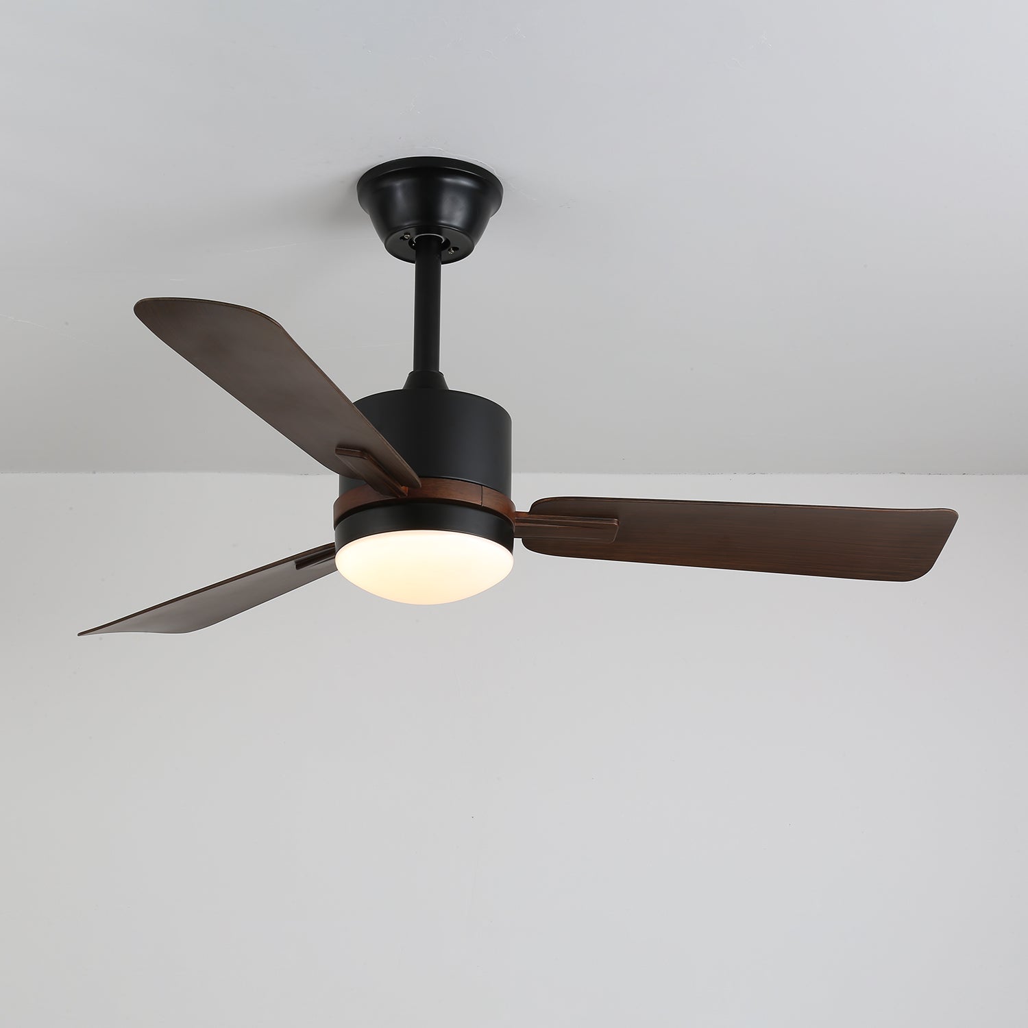 Primer plano de las aspas de madera de nogal del ventilador de techo Zeyra con luz