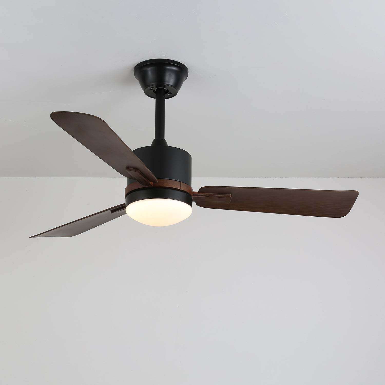 Primer plano de las aspas de madera de nogal del ventilador de techo Zeyra con luz