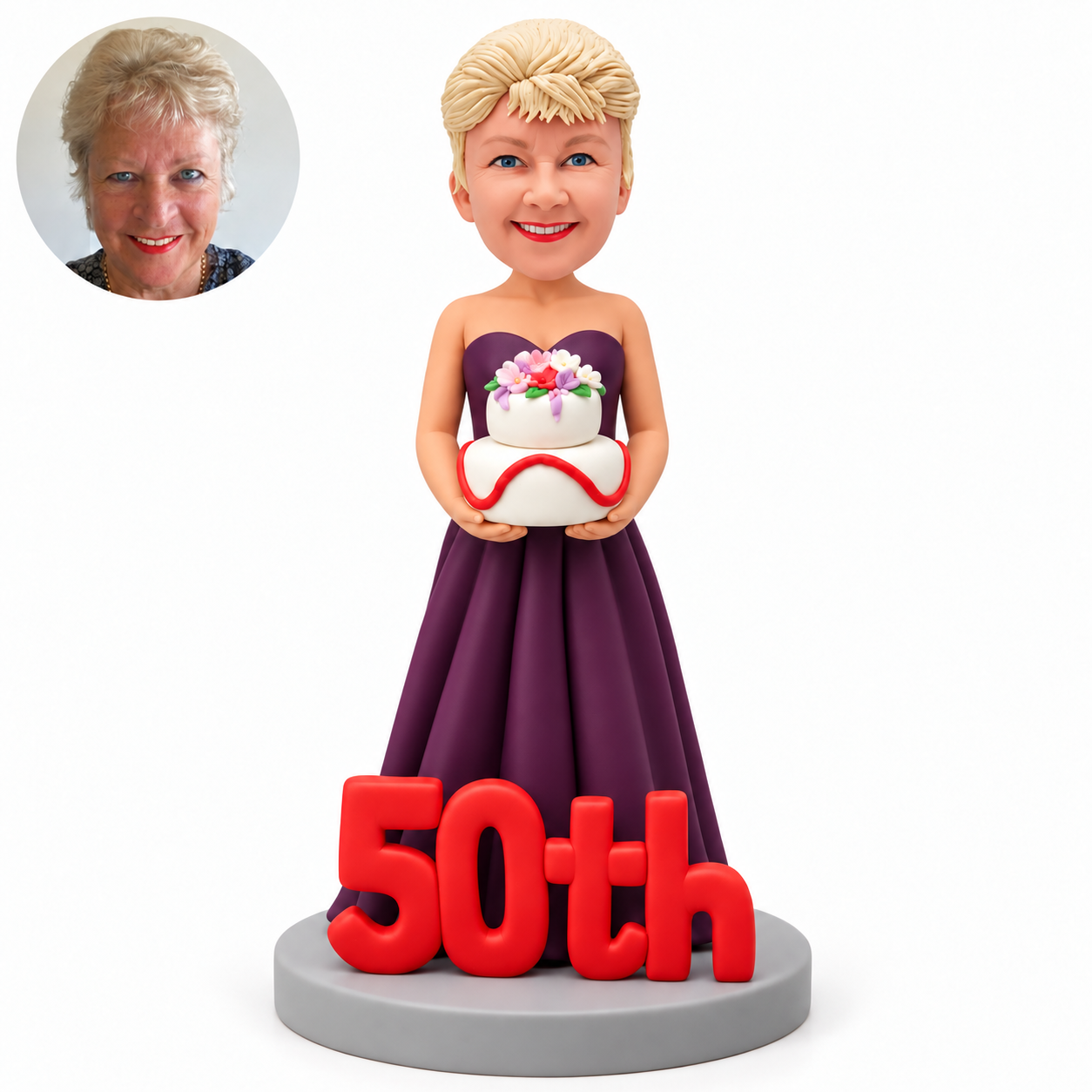 custom bobblehead figure woman holding a two tier birthday cake behind a large 50th display