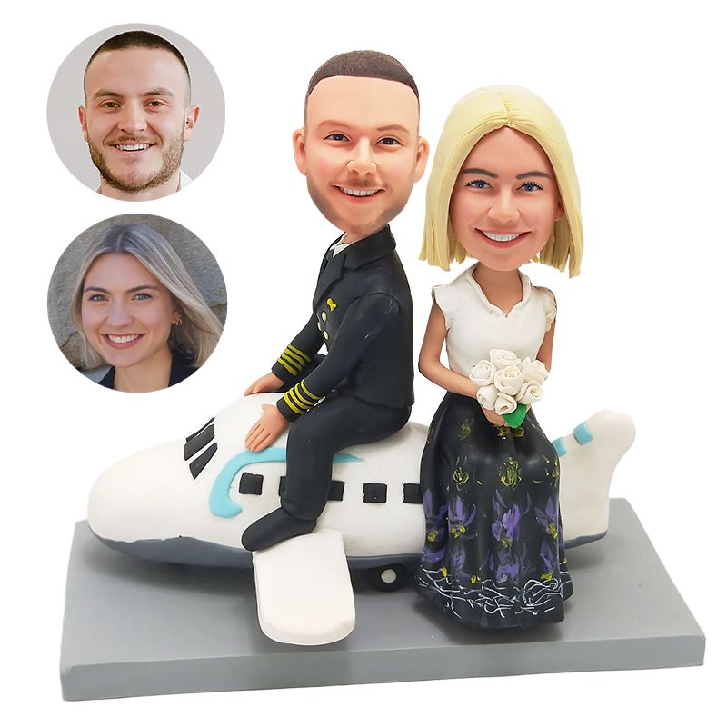 custom bobble head couple holding flowers beside a plane