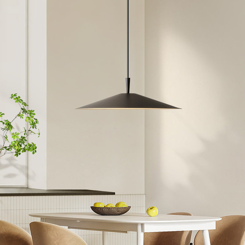 Modern black pendant light above a dining table