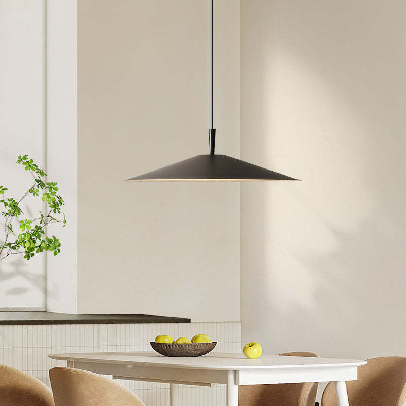 Modern black pendant light above a dining table