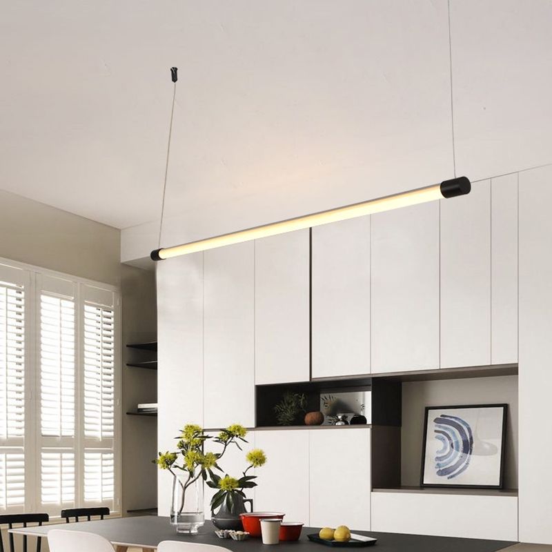 Minimalist linear pendant light above dining table.