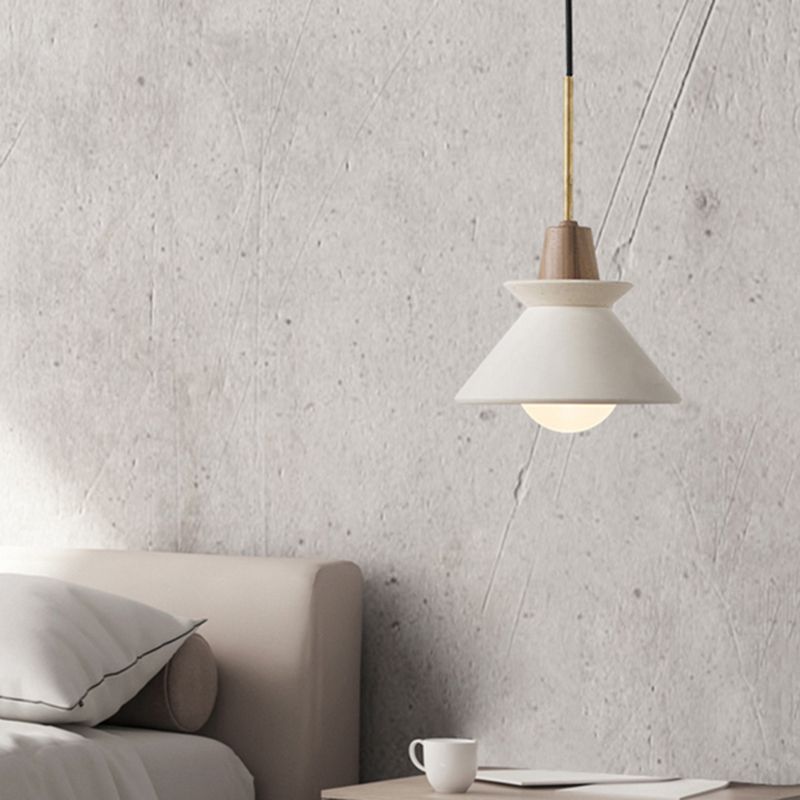 Modern pendant light, cement lampshade in bedroom setting.
