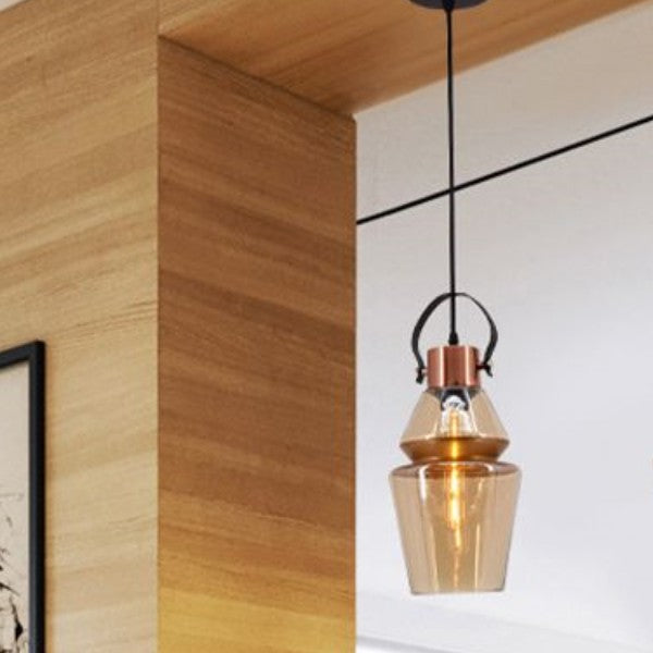 Alessio amber glass pendant light near wood accent wall.