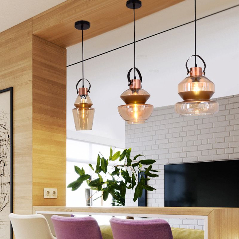 Amber glass Alessio pendant lights in modern dining room.