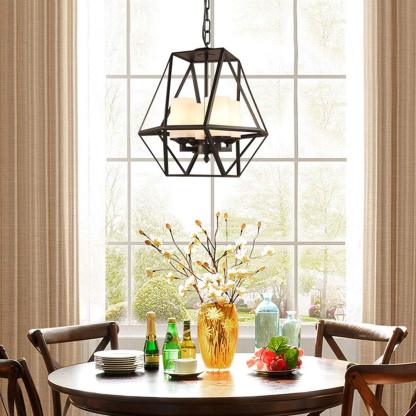 Industrial pendant light over dining table. Black metal cage design.