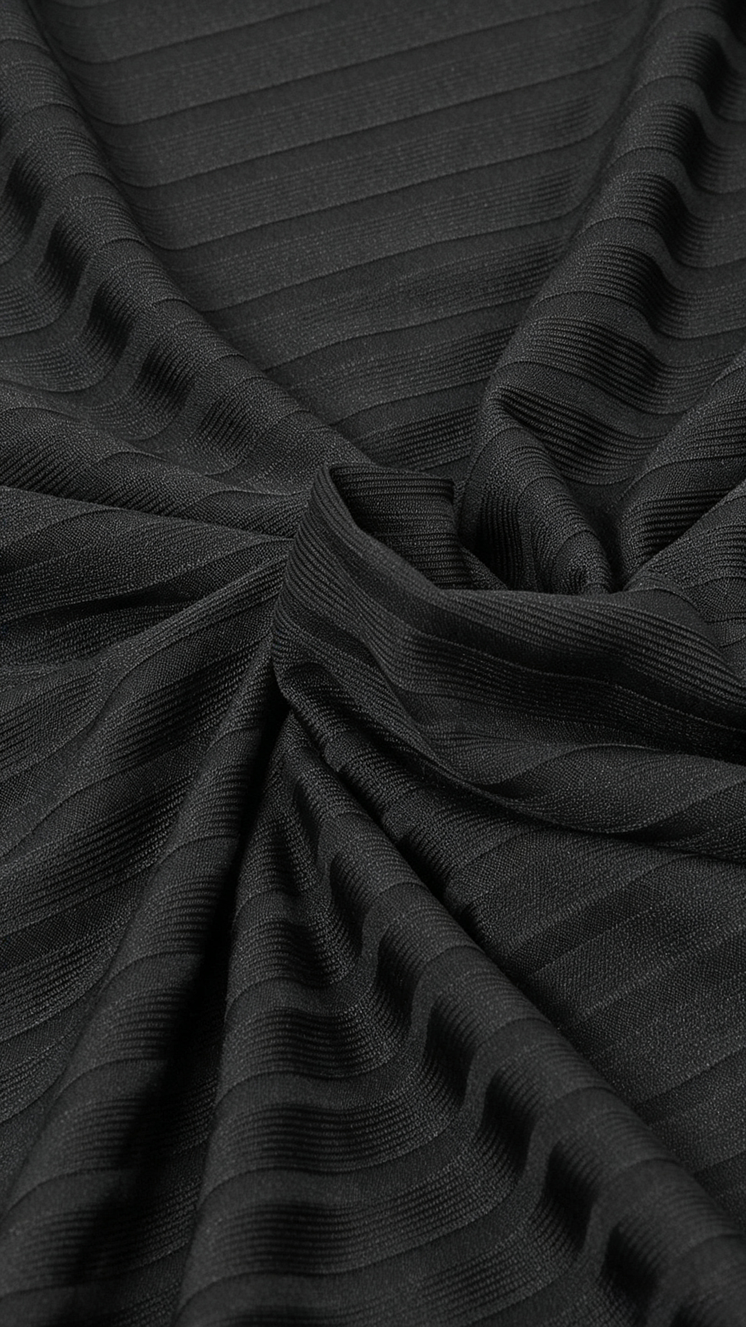 Black pleated knit fabric texture cape dress with flowing fringe details close up