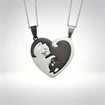 Two matching silver heart-shaped pendant necklaces with cat cutouts, displayed against a light gray gradient background.