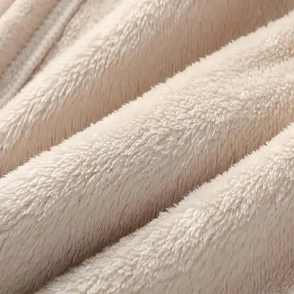 Close-up of a soft plush fabric in a warm off-white or cream color, showing the texture and folds of the material.