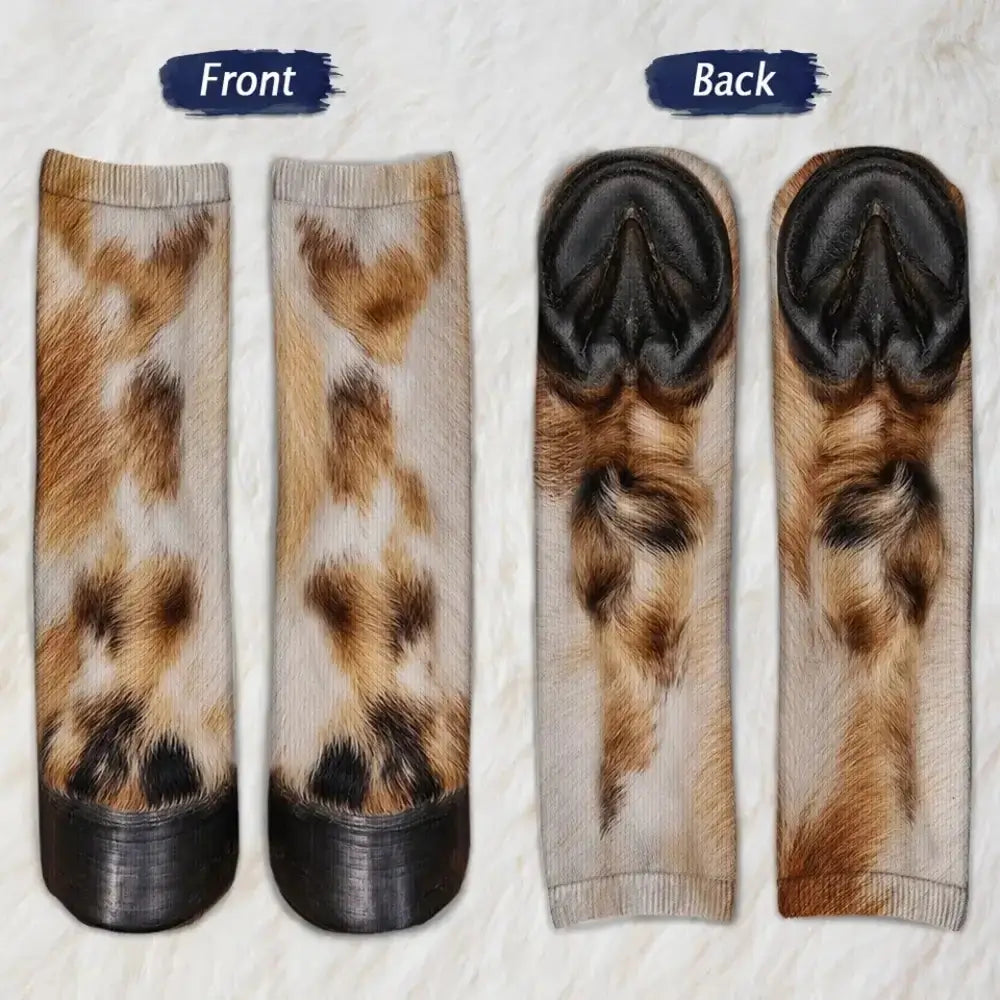 Cow fur patterned socks shown from front and back with black hoof toes on a fluffy white background