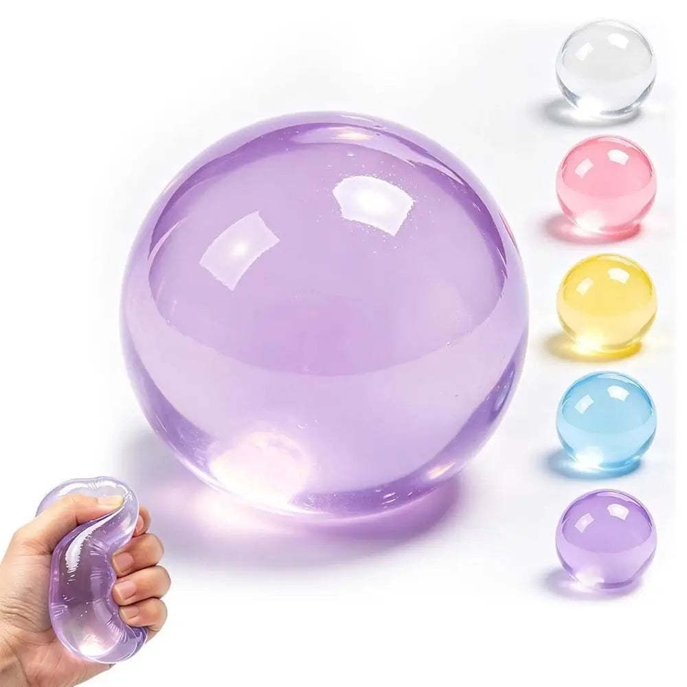 A translucent purple stress ball being squeezed by a hand, with five smaller color variants lined up on the right: clear, pink, yellow, blue, and purple. The main ball is lavender purple, and the hand demonstrates its squishy texture.
