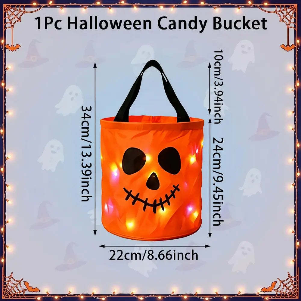 An orange pumpkin-shaped Halloween candy bucket with black handles and a stitched jack-o'-lantern face