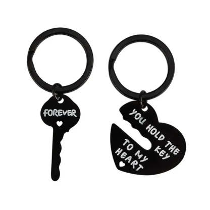 Black key and heart-shaped keychain with engraved text on a white background
