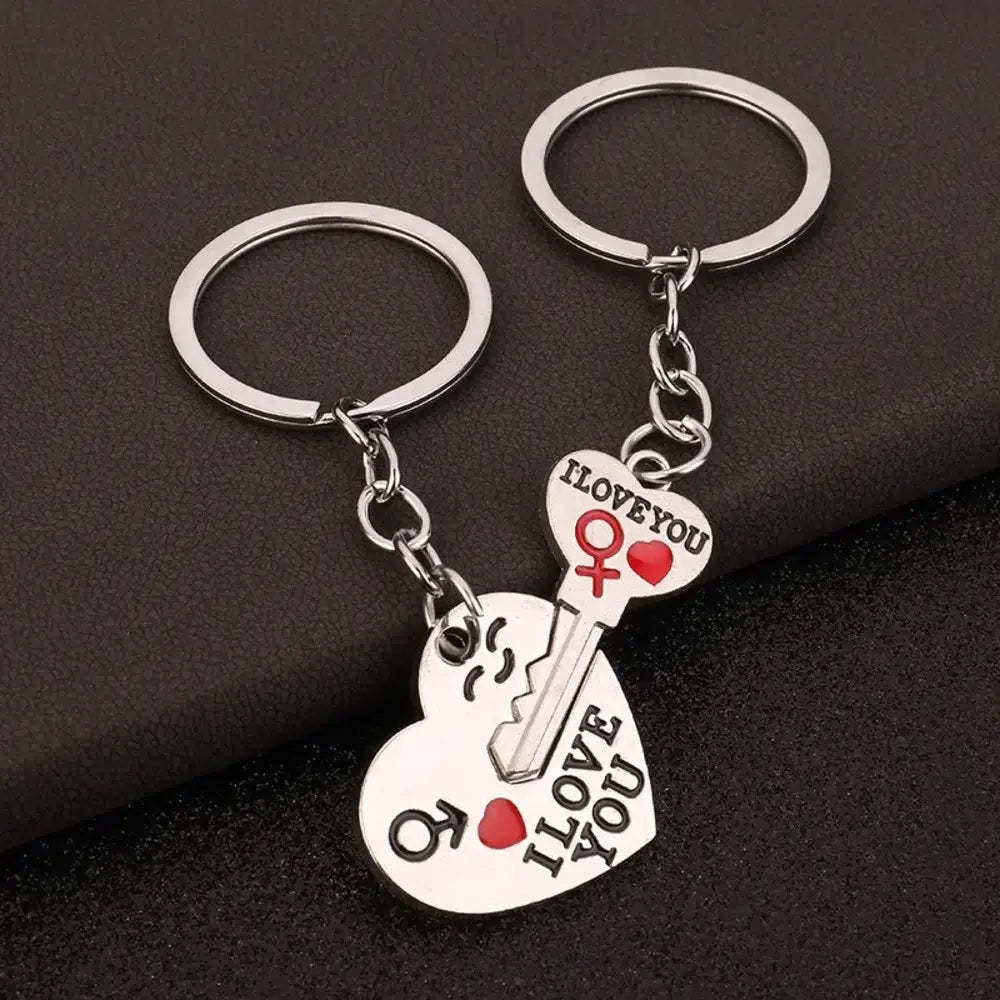 Two keychain pairs with heart and key designs on a dark background