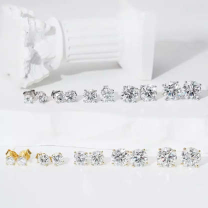 Pair of solitaire moissanite stud earrings displayed with jewelry