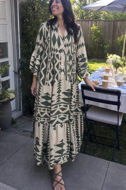 Woman wearing the green geometric maxi dress at a backyard brunch