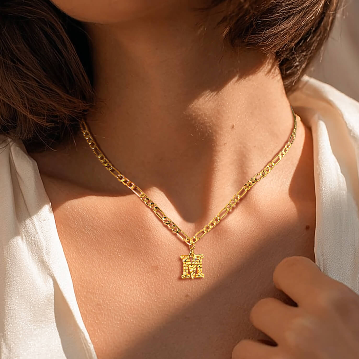 woman wearing gold initial necklace