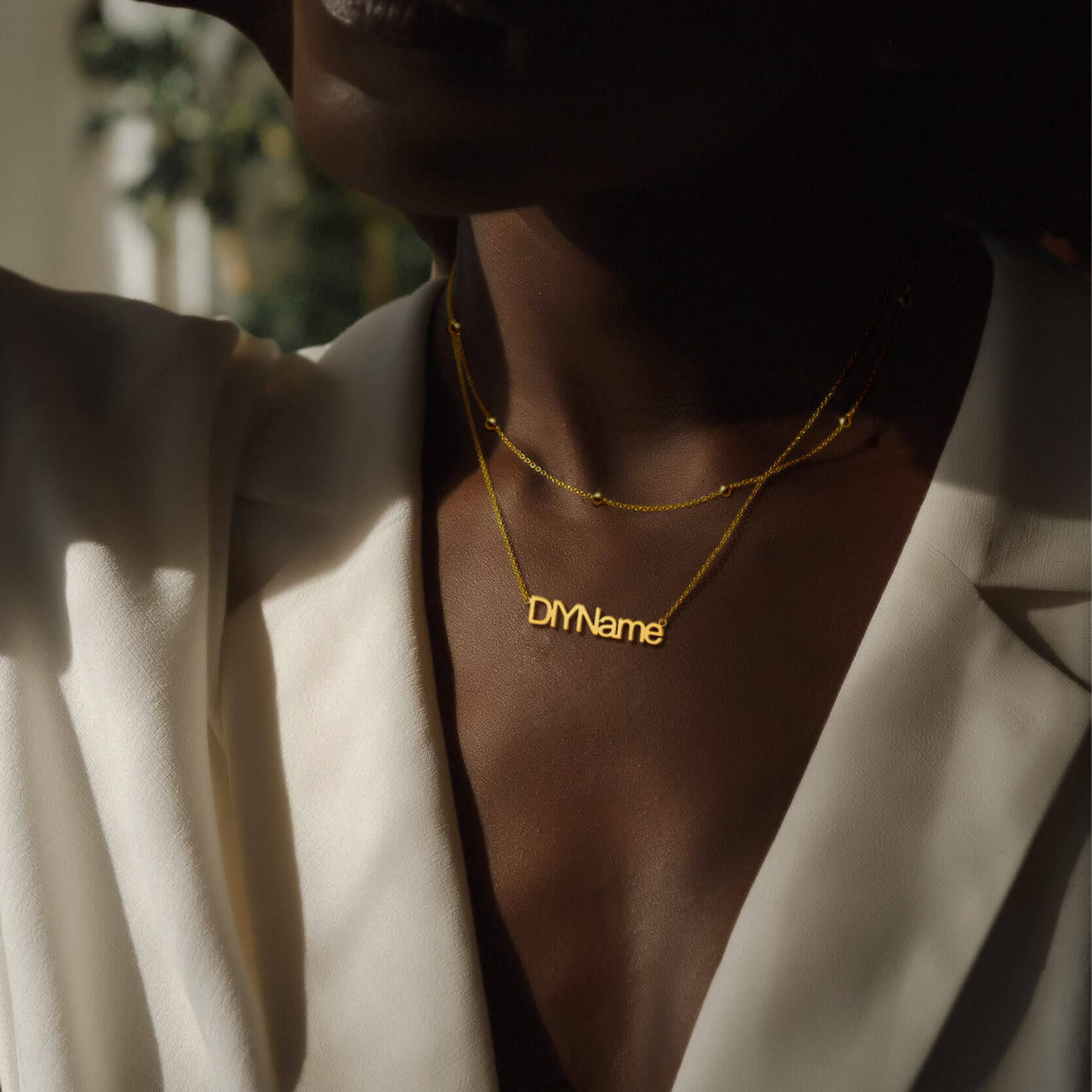 woman wearing gold name necklace