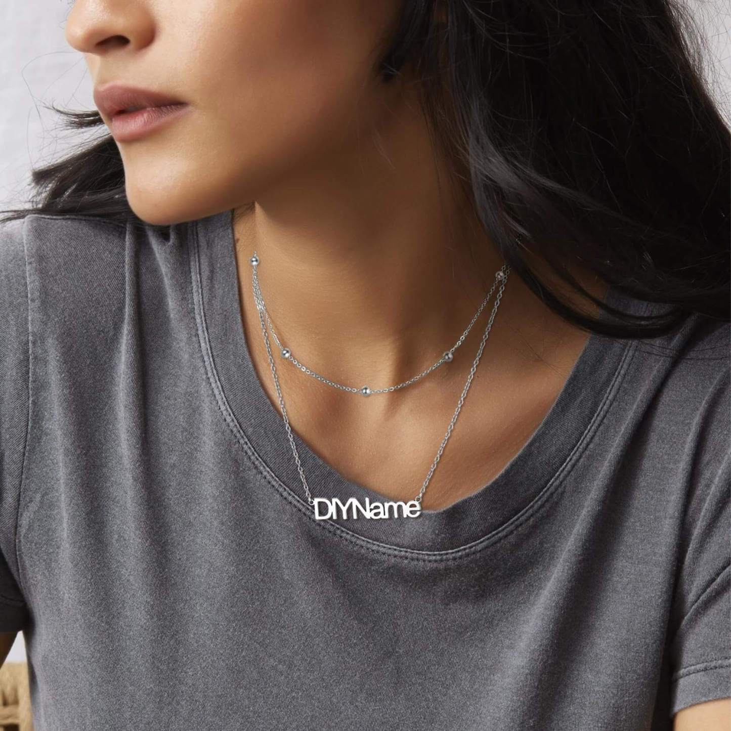 woman wearing silver name necklace