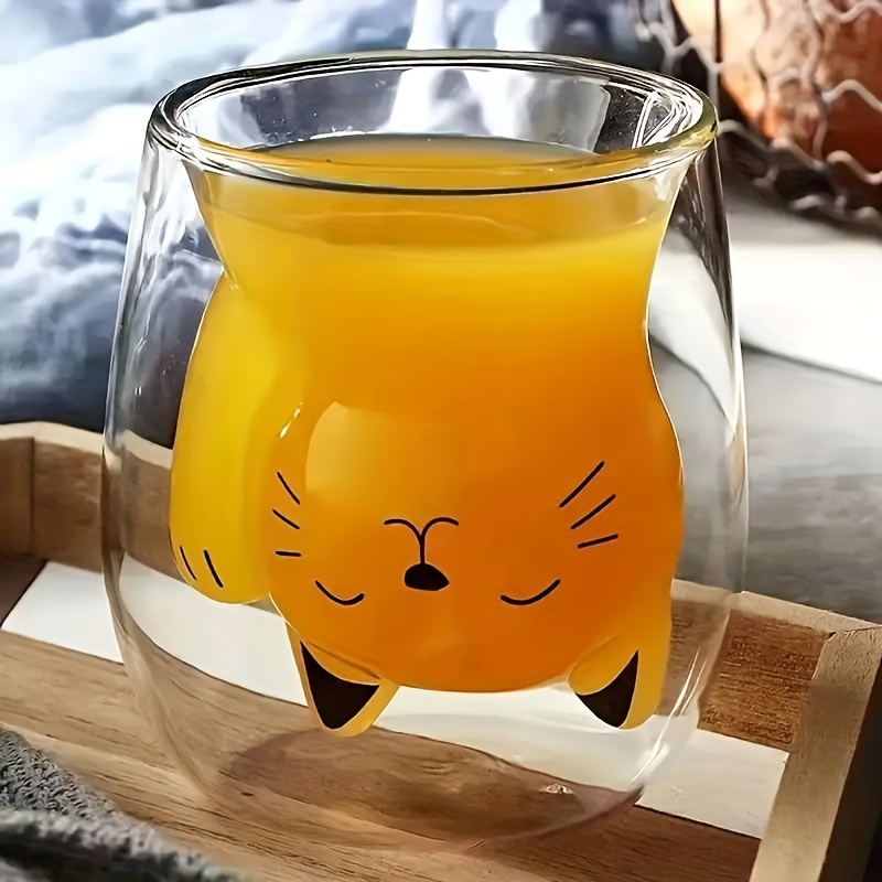 Double wall glass cat cup filled with orange juice