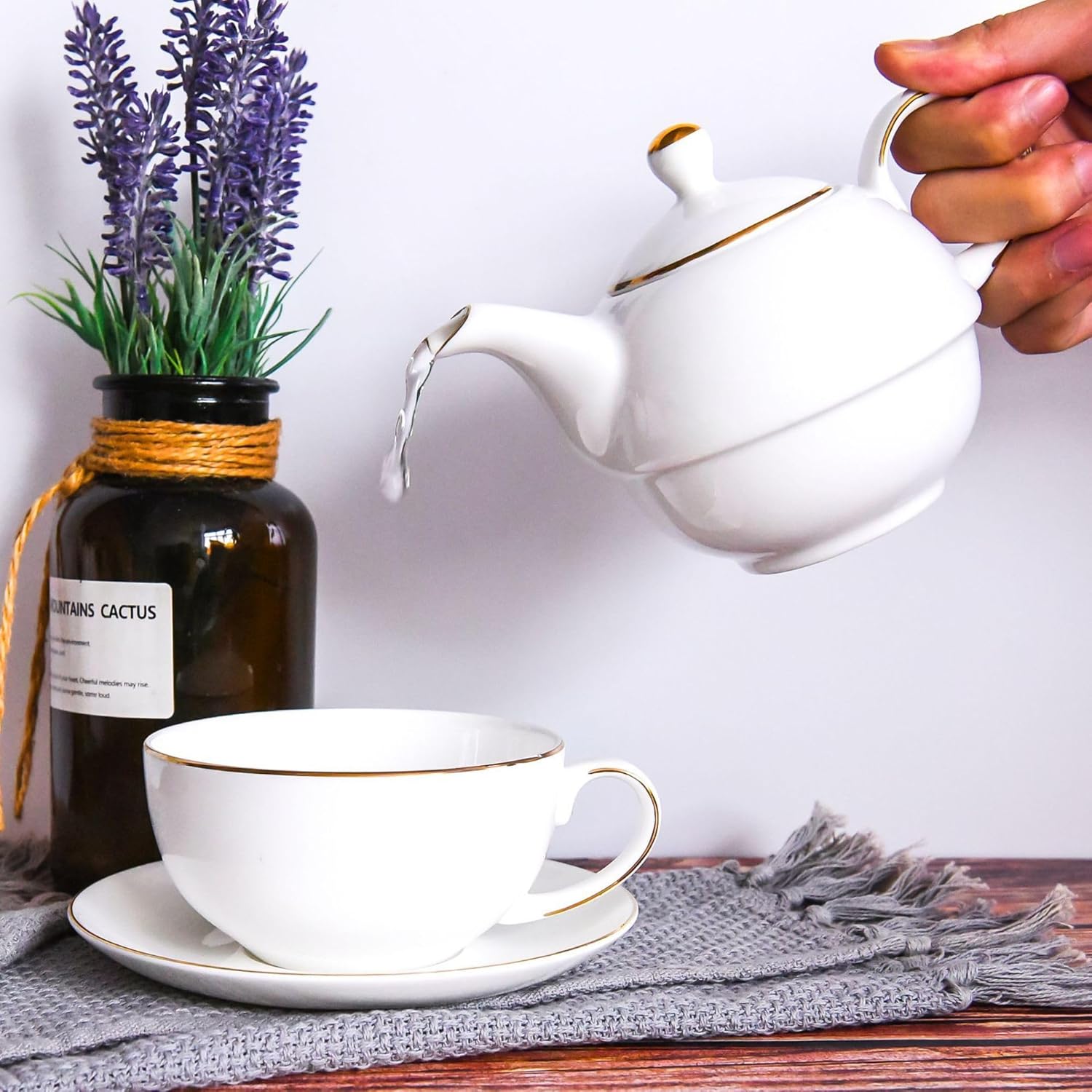 Single-serving ceramic teapot and cup set arranged on a tabletop
