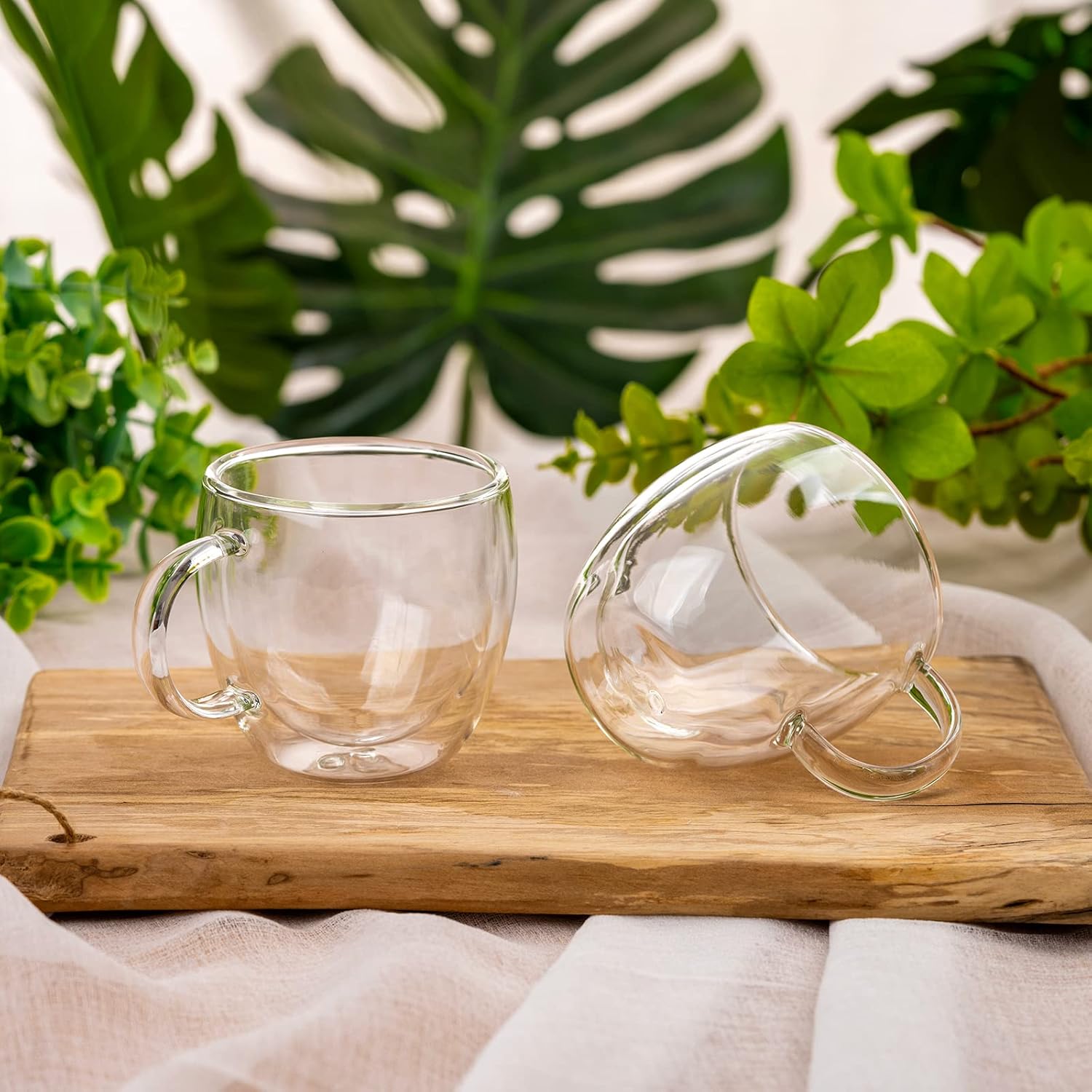 Two empty 5 oz clear handled espresso cups on a wooden tray