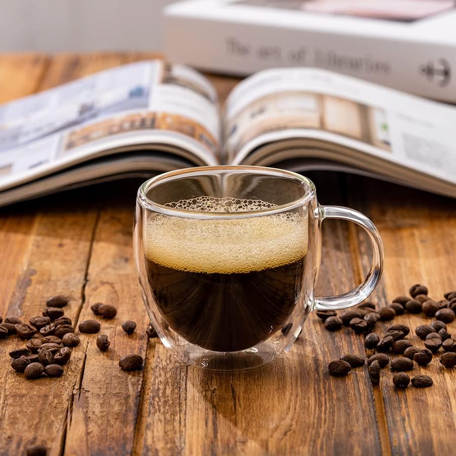 Single 5 oz clear handled espresso cup filled with coffee on a wooden table