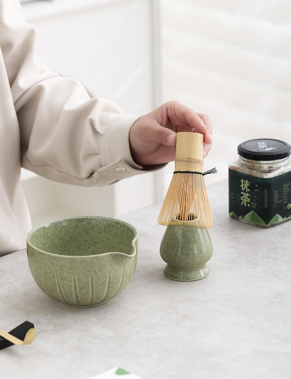 Five-piece ceramic matcha set arranged on a tray with bowl, whisk, scoop, holder, and sifter