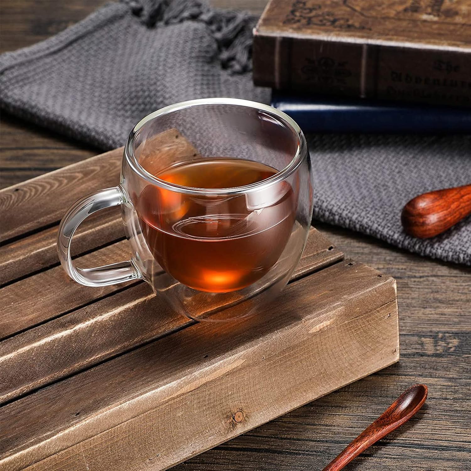 Clear 5 oz espresso cup with handle used for tea on a wooden tray
