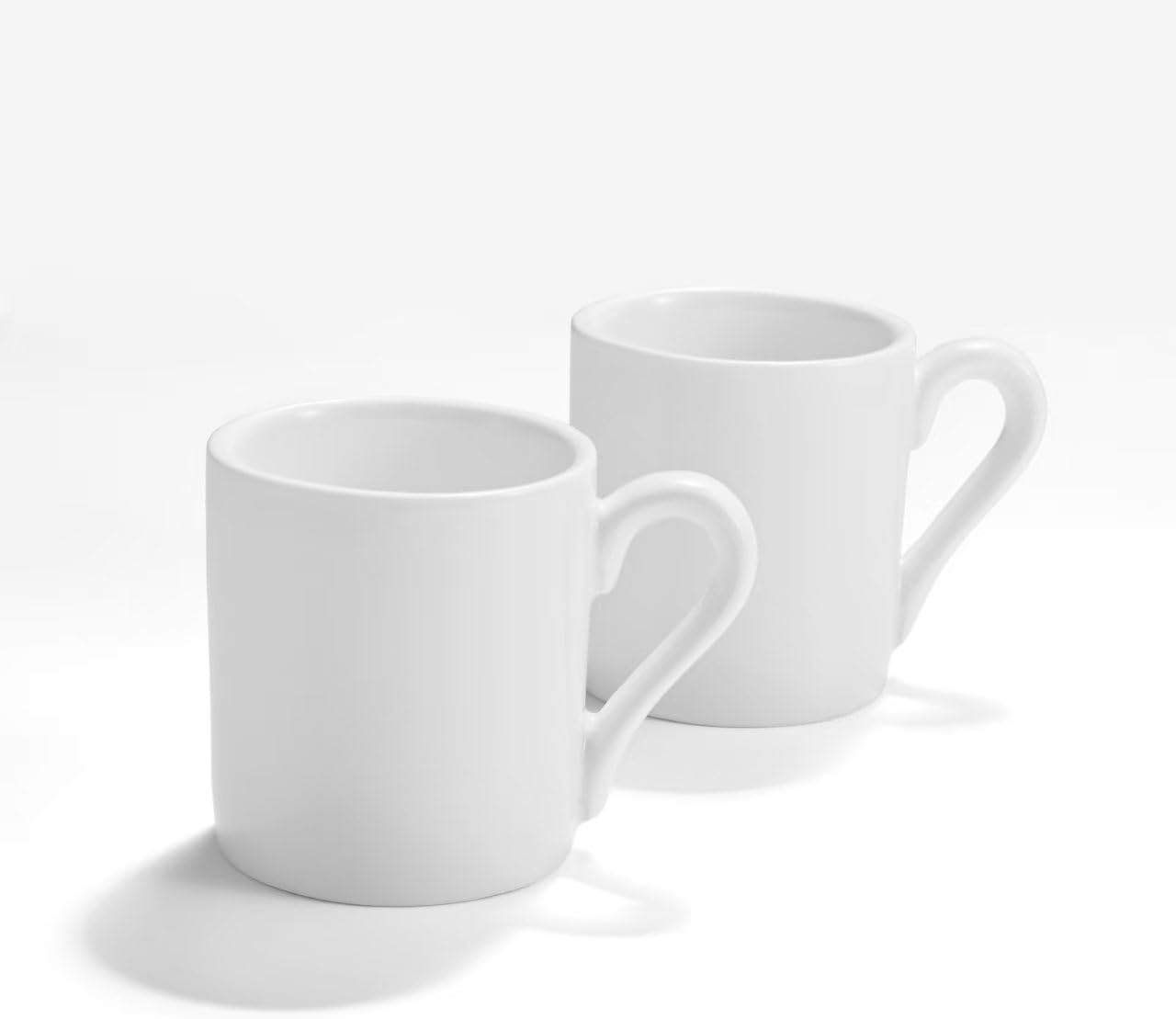 Front view of two white ceramic espresso cups with a clean minimalist look