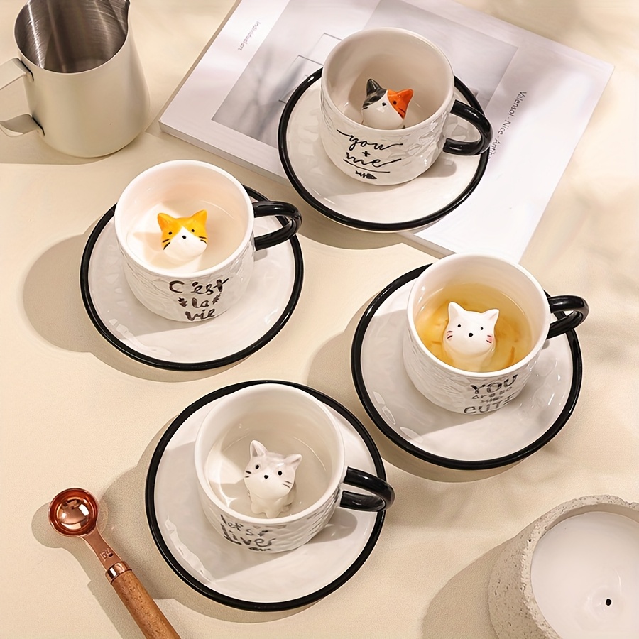 Little gray cat inside cup and saucer