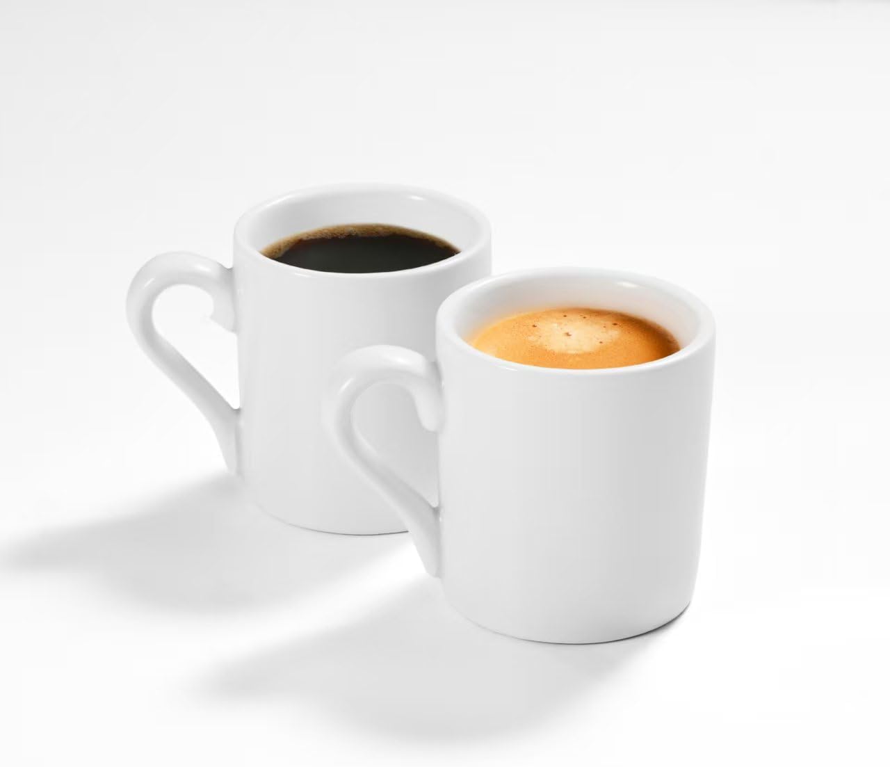 Set of two white 2 oz ceramic espresso cups filled with espresso