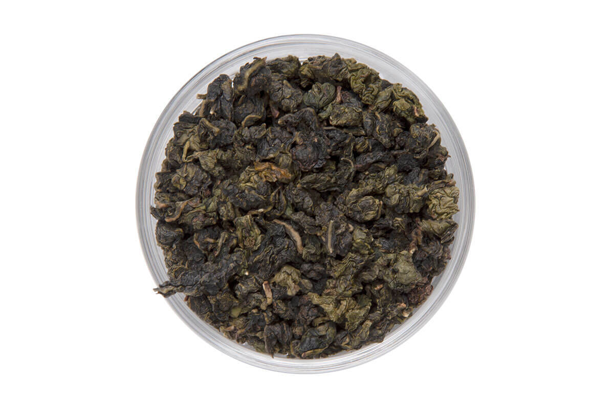 Close-up of premium Milk Oolong tea leaves with twisted, dark green appearance and hints of creaminess