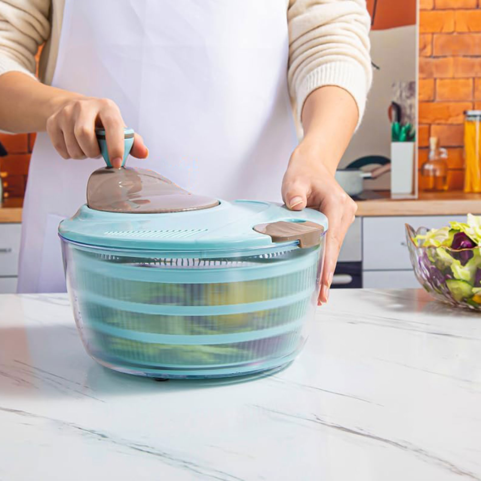 salad spinner with lettuce inside showing double drain holes in use