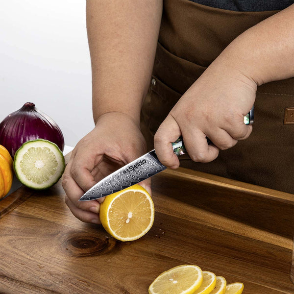 A chef using the Awabi paring knife to slice a lemon against a cutting board