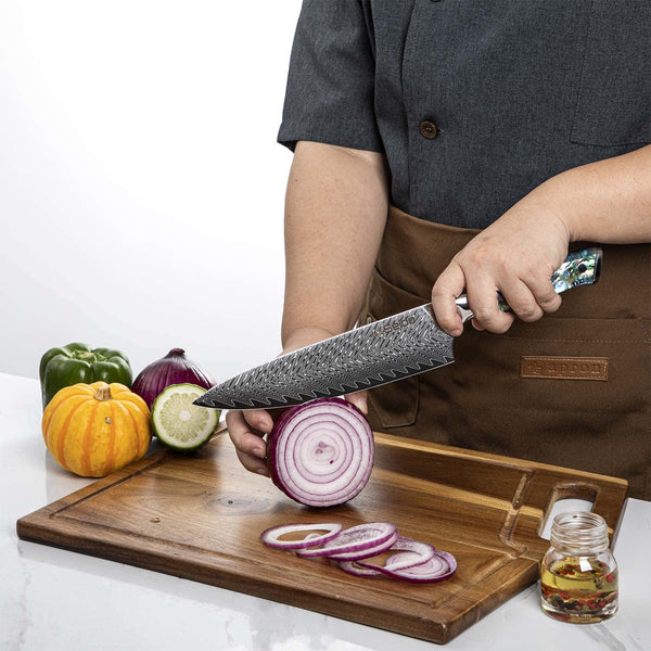 A chef using Seido's Awabi series Chef knife to cut an onion against a cutting board