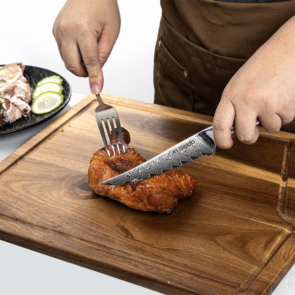 A chef using the Awabi serrated steak knife to saw through friend chicken