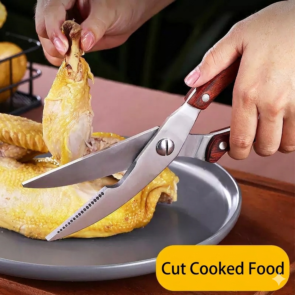 Close-up shot of a hand using the heavy-duty kitchen shears to easily cut through a cooked chicken leg on a grey plate, illustrating the product's performance with a yellow text box that reads 'Cut Cooked Food'.