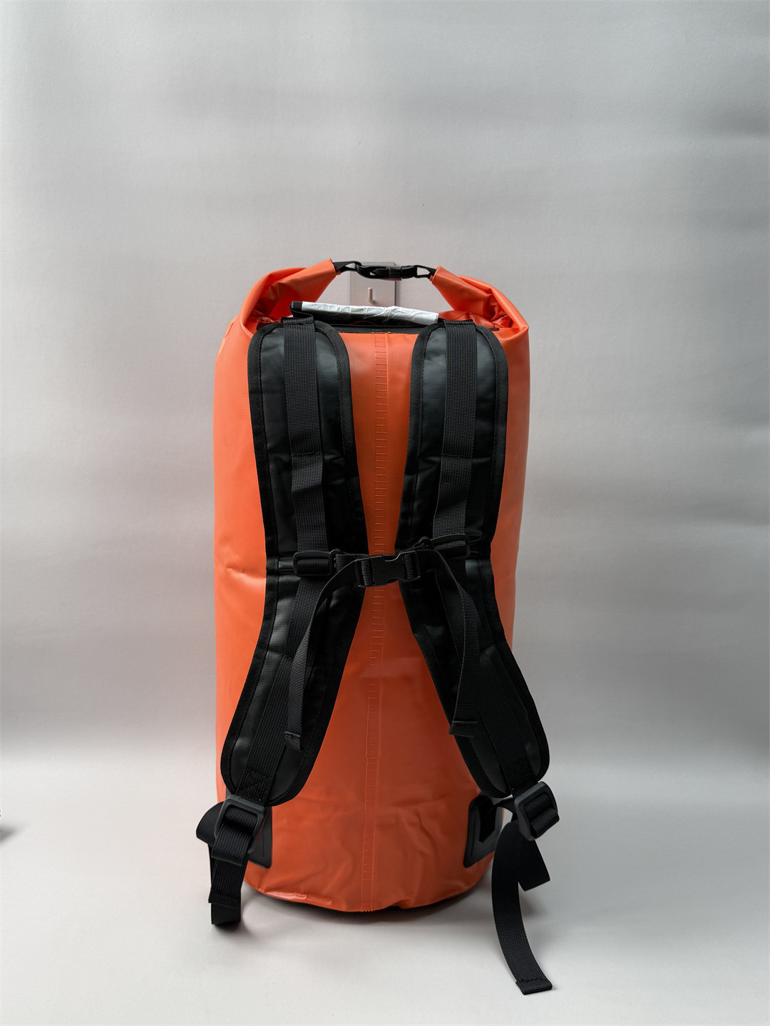 Rear view of the orange roll top waterproof backpack 40L showing adjustable sternum straps and padded back support.