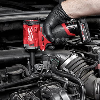 A man uses an M18 FUEL 3/8 Stubby Impact Wrench to remove a stubborn fastener in a confined workspace.