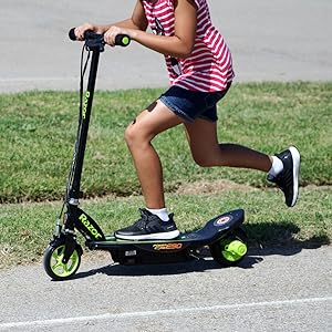 razor; electric scooter; girl riding on green scooter on pathway