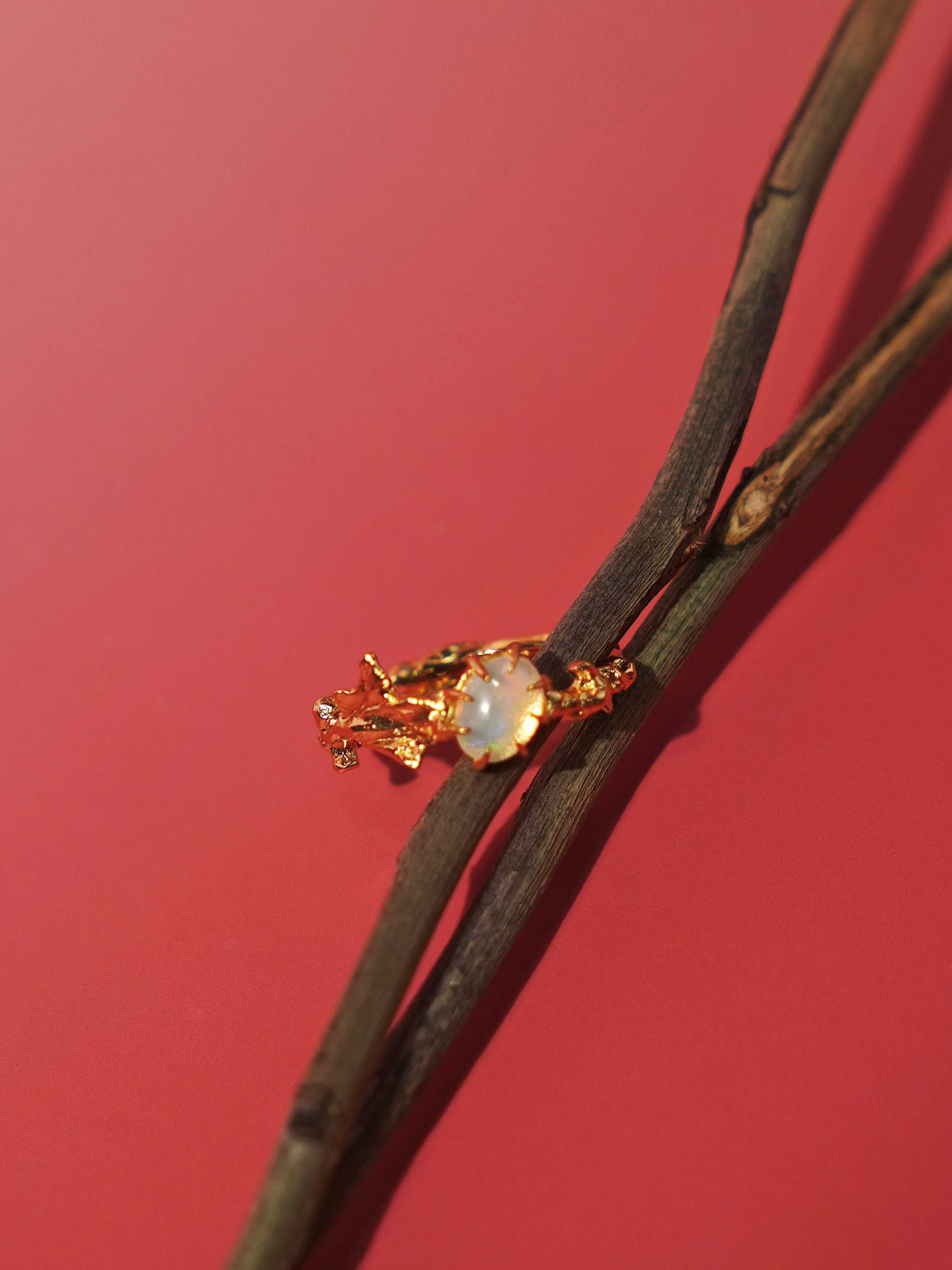 Ranunculus Leaf Opal Ring with red background