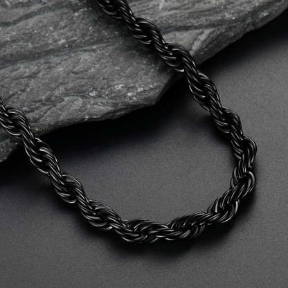 Black braided necklace on a dark surface with a stone background