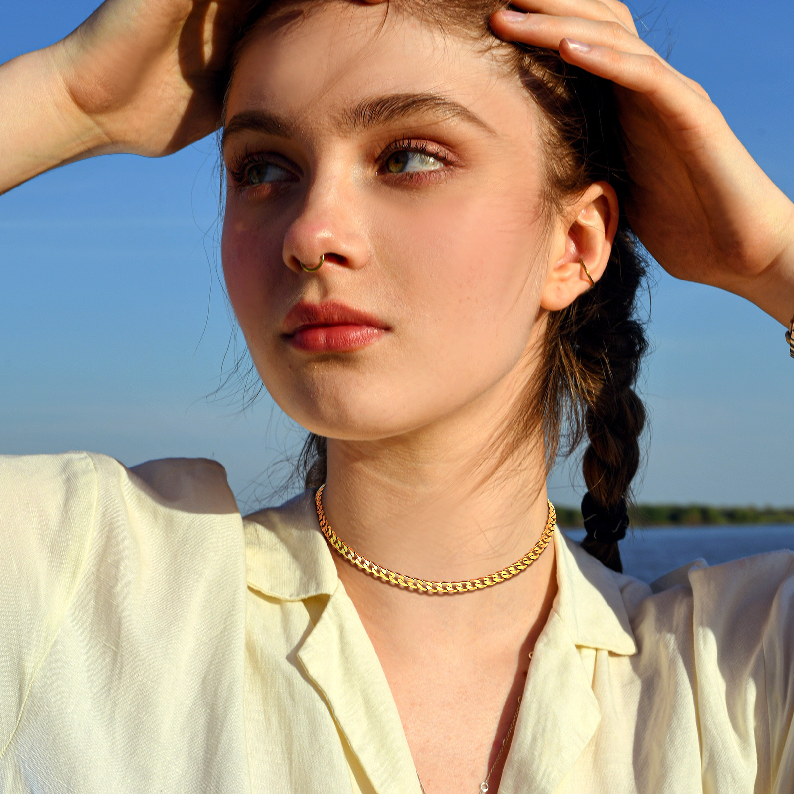 Female model wearing a gold stainless steel curb chain necklace outdoors in natural light