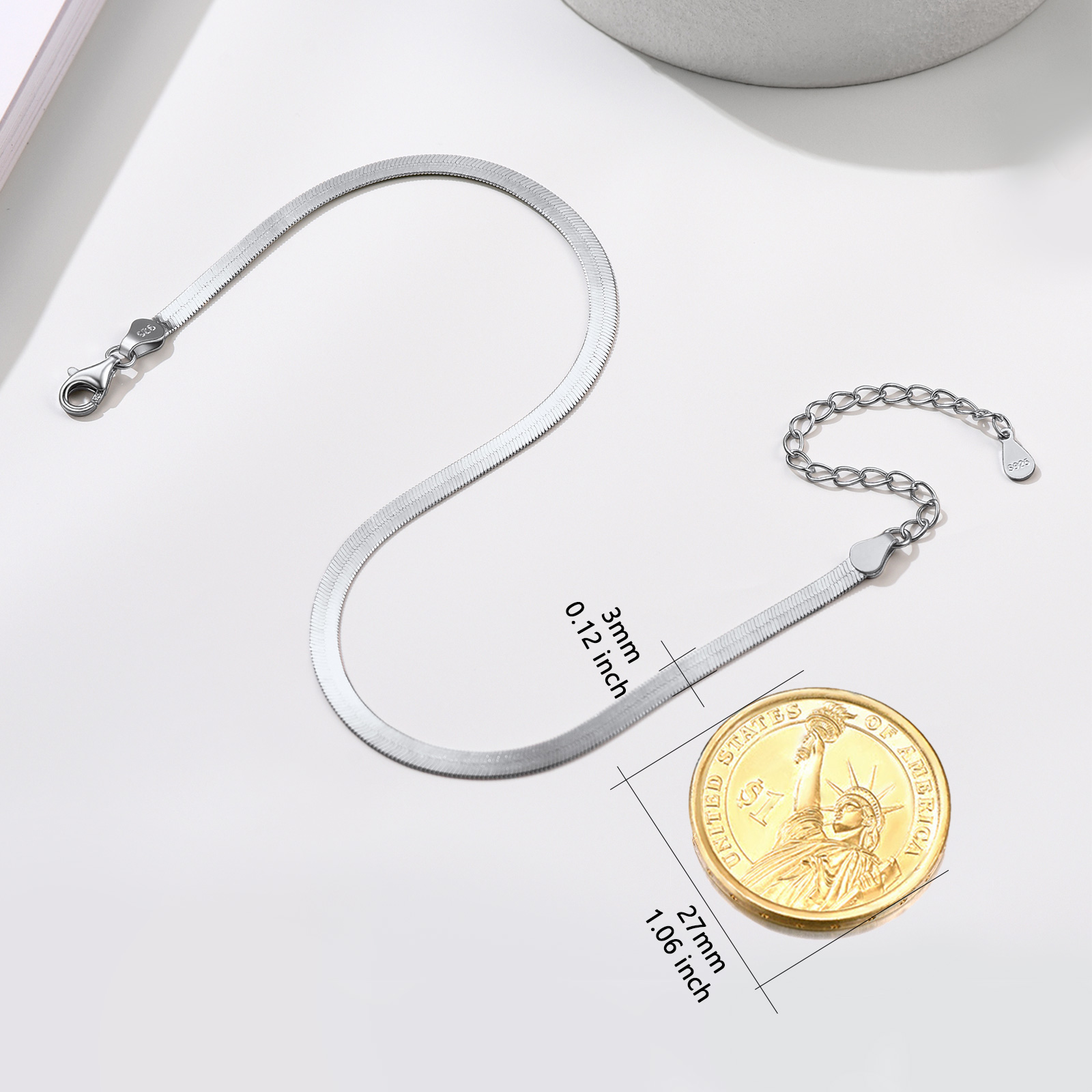sterling silver snake chain bracelet with lobster clasp and extension chain, displayed next to a US coin for size comparison