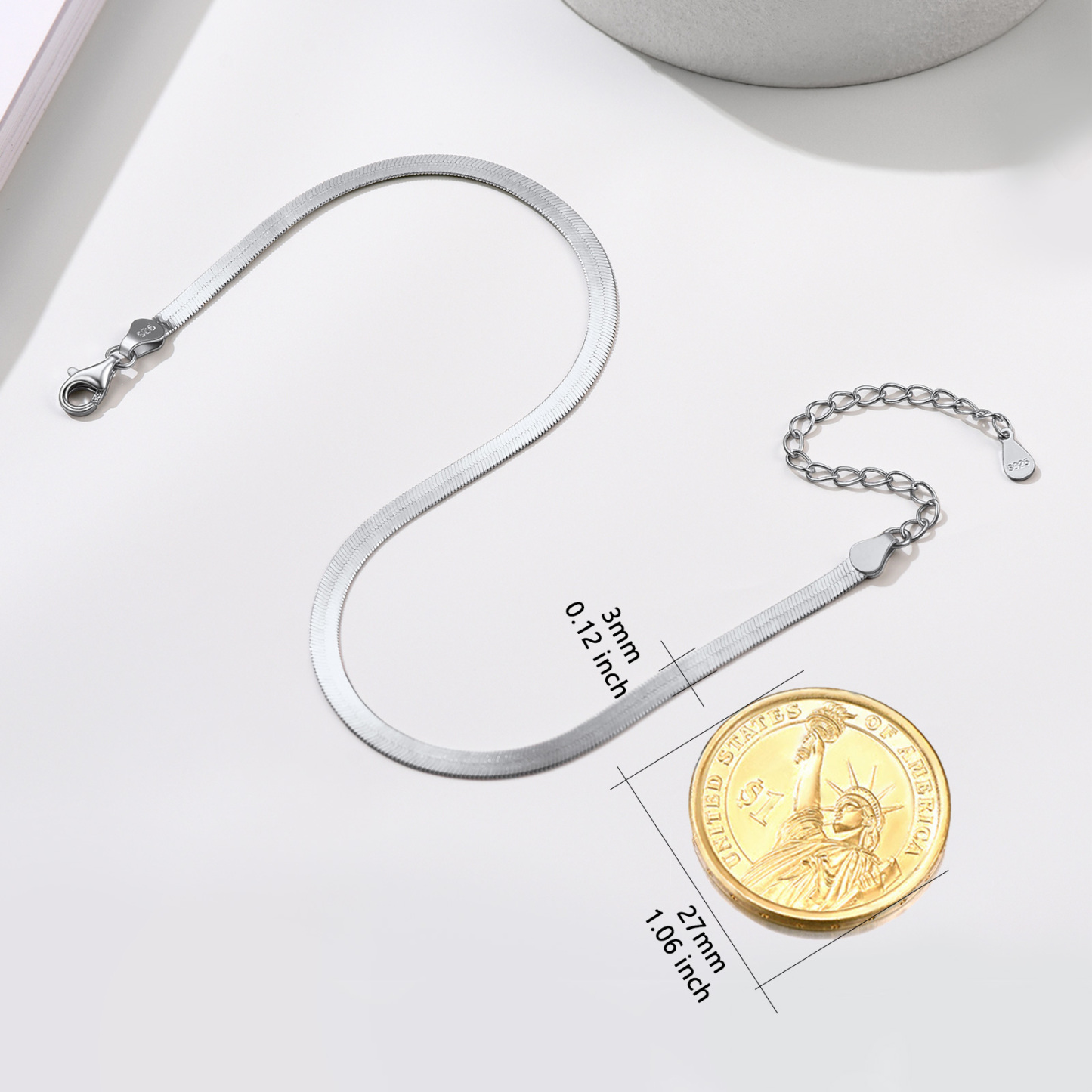 sterling silver snake chain bracelet with lobster clasp and extension chain, displayed next to a US coin for size comparison