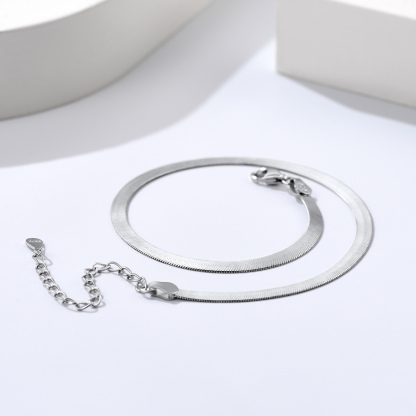 Detailed still life of a polished sterling silver snake chain necklace with clasp