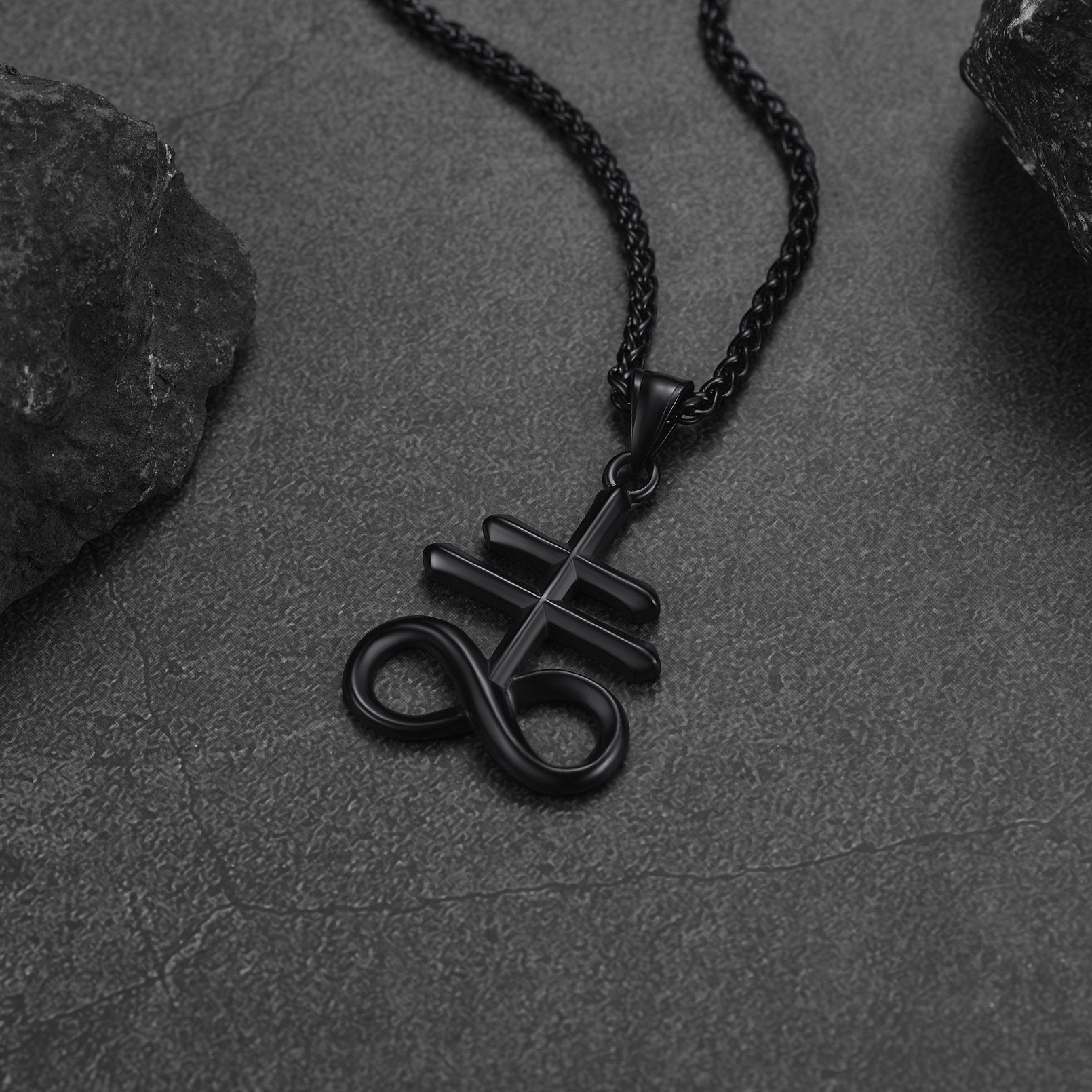Black Leviathan Cross necklace on dark stone background